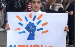 Teen holding #enough sign