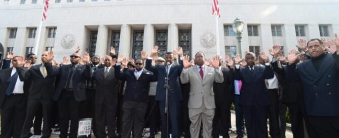 Black men with hands raised